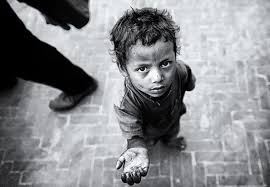 “Little child standing in front of a man, reaching up with one hand asking for food”