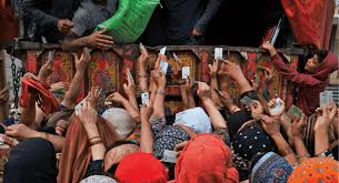 “Humanitarian van arriving with food as people in crisis crowd around it for survival”
